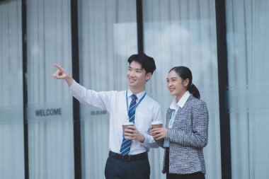 Ofisteki iş arkadaşları ofis binasının dışında yeni projeleri tartışıyor, dijital tablet tutuyorlar. Ofis binalarının önünde duran iki iş arkadaşı iş planını tartışıyor.