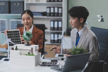 kadın alternatif enerji mühendisi bir yel değirmeni güç örnek model tutun ve stüdyoda alternatif güç kaynağı için onun erkek arkadaşı ile tartışmak