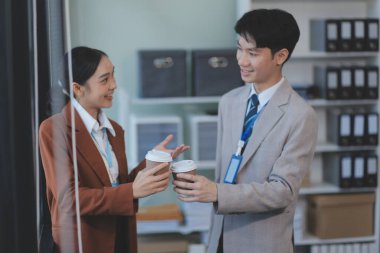 Başarılı genç iş adamları modern iş binası önünde konuşuyor, birlikte çalışıyorlar.