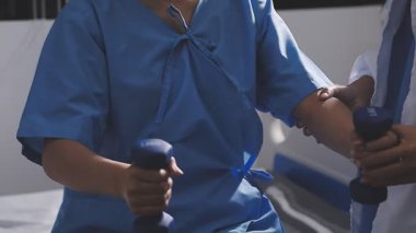 Yakın çekim - erkek doktorun dambıl tutuşu