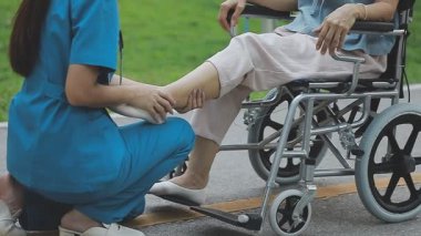 Tekerlekli sandalyedeki Asyalı kadın