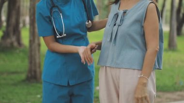 Doktor ve hemşire tıp önlüğü içinde el ele tutuşuyorlar.