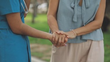 Genç bayan doktor hastanede el ele tutuşuyor.