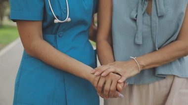 Doktor ve hemşire parkta el ele tutuşuyorlar.