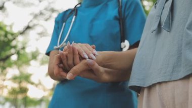 Kadın hemşire doktorla el ele tutuşuyor..