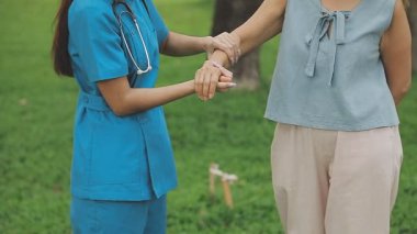 Üniformalı bir doktor hastanede genç bir hastayı muayene ediyor.