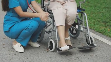 Engelli bir kadın tekerlekli sandalyede oturuyor ve konuşuyor.