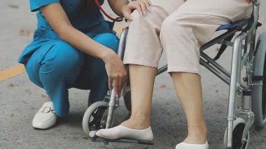 Hemşire yürüteçle genç bir kadına yardım ediyor.