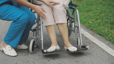 Parkta tekerlekli sandalyeli engelli kadın
