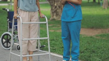 Hemşire, genç bayana hastanede yürüyüş turlarında yardım ediyor. Sağlık konsepti.,