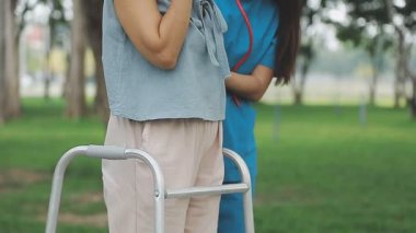 Hastanede hemşiresiyle tekerlekli sandalyede oturan bir kadın..