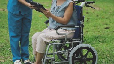 Tablet bilgisayarlı tekerlekli sandalyedeki kadın doktor..