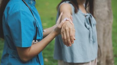 Doktor ve hemşire el ele tutuşuyorlar.