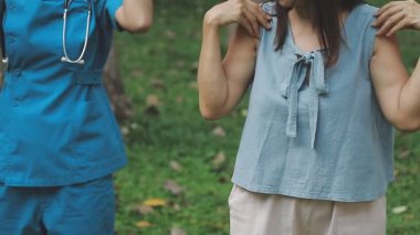 Genç bayan doktor ve hastası bahçede.