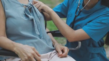 Steteskop ve hasta el ele tutuşan genç kadın doktor. Tıbbi bakım konsepti, sağlık ve tıbbi konsept.