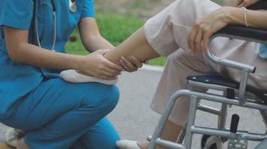 Bir hemşireyle tekerlekli sandalyedeki kadın.