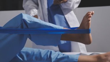 Yerde mavi kurdeleli, tıp üniformalı genç bir kadın.