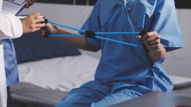 Doktor Eli steteskobu tutuyor ve hastanede tablet kullanıyor..