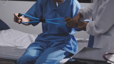 Modern bir hastanede fizik tedavi gören mavi üniformalı genç bir doktor.