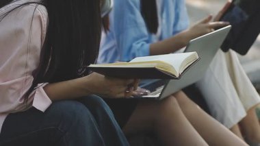 Genç bir kadın sandalyede oturup kitap okuyor.