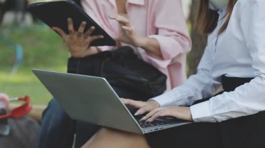 Şehir parkında, açık havada dizüstü bilgisayarda çalışan iş kadınları