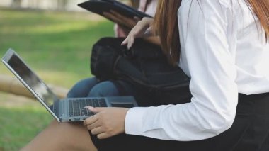 İş kadını parkta dizüstü bilgisayar kullanıyor..