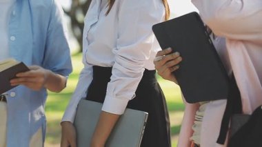 Ellerinde kitaplarla üniformalı öğrenciler.