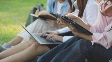 Kampüsteki çimlerde oturan öğrenciler