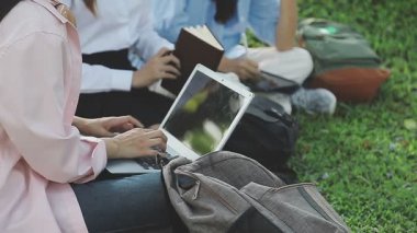 Parkta tablet bilgisayar kullanan Asyalı kadın