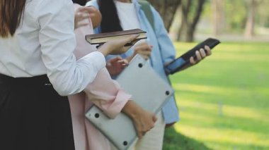 Genç kadınlar parkta bir tablet tutuyorlar.