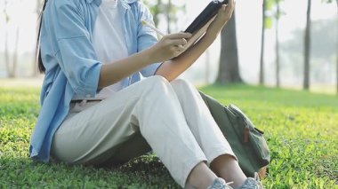 Bahçede tablet bilgisayar kullanan genç Asyalı kadın, serbest çalışma kavramı.