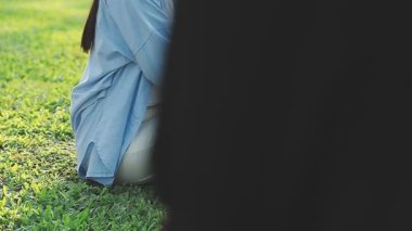 Genç bir kadın parkta defter yazıyor..