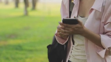 Parkta akıllı telefon kullanan kadın..