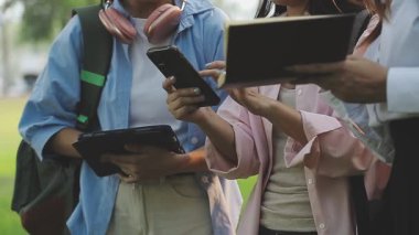 Asyalılar birlikte tablet bilgisayar kullanıyor, rahatlayın ve parkın tadını çıkarın..