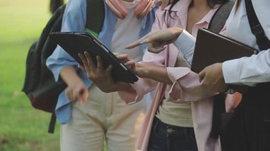 Bahçedeki bir grup genç elinde tabletle