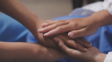 Genç bayan doktor hastanede el ele tutuşuyor.