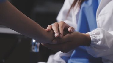 Doktor hasta elini tutarak