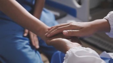 Kapalı - Kadın doktor ve el ele tutuşan hasta hastanede.