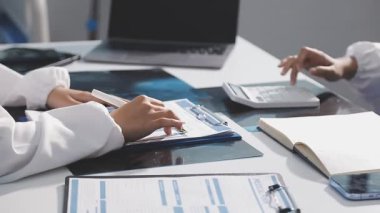 Hastanedeki hastasına danışan genç bir kadın doktor..