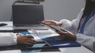 Doktor ofiste dizüstü bilgisayarla çalışıyor.