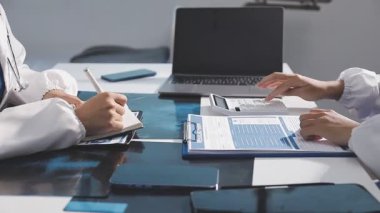 İki iş adamı modern ofiste mali raporu tartışıyor.