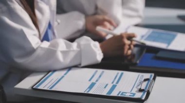 Klinikte doktor elinde kalem ve kağıt tutuyordu..