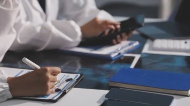 Kapalı - dijital tableti tutan ve sonuçları tartışan kadın doktorların elleri