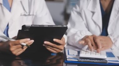 Ofiste elinde tablet tutan genç bir kadın doktor.