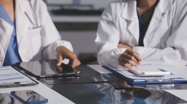 Kadın doktor elinde tabletle ofiste konuşuyor.