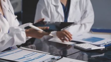 Bir grup doktor tıbbi belgeleri tartışıyor.