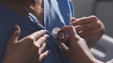 Doktor klinikte hastanın kalp atışlarını kontrol ediyor.