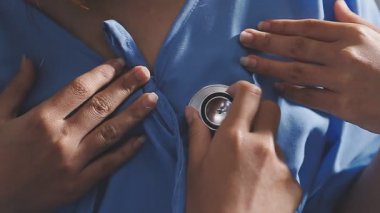 Yakın çekim - kadın doktor elleri stetoskop tutuyor.