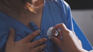 Kadın doktor steteskopu hastanede tutuyor.