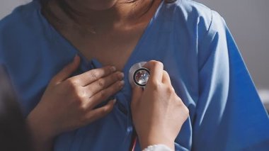 Klinikte steteskopu inceleyen bir doktor